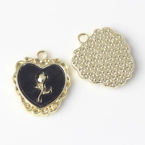 Detail of alloy heart pendant with gold rose relief and star pattern back for DIY jewelry