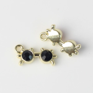 Vue macro de breloques lunettes dorées avec zircons noirs pour bijoux artisanaux