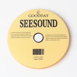Macro shot of gold acrylic CD record pendant with SEESOUND engraving and hanging hole
