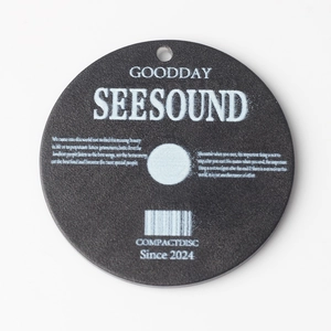 Macro shot of circular acrylic CD charm with matte black finish and white retro lettering