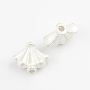 Macro detail of fan-shaped matte silver alloy spacer beads for DIY jewelry making