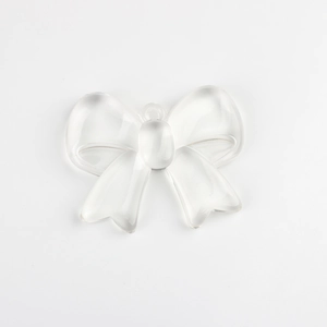 Close-up of transparent resin bow pendant with top hole for DIY jewelry making