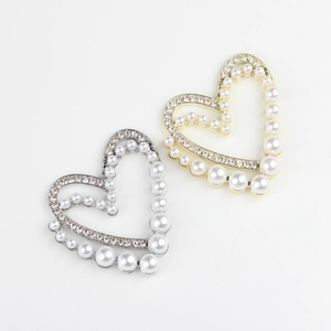 Detailed view of alloy heart charms with pearl and zircon inlay in gold and silver