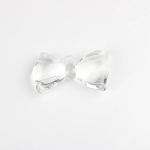 Detailed view of a clear acrylic bow pendant for DIY jewelry with a smooth transparent finish