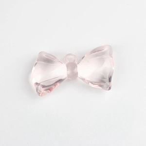 Detailed close-up of pink translucent resin bow pendant for DIY jewelry making