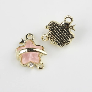 Macro detail of pink enamel star jewelry connector with gold plating and cubic zirconia