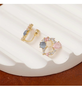 Détail macro d'un clip d'oreille en forme de cœur avec zircon rose et œil-de-chat