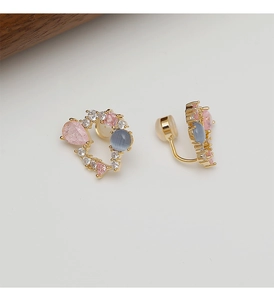 Détail du clip d'oreille floral doré avec gemmes roses et coussinets en silicone