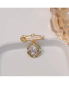 Detailed view of vintage coin brooch with pearl pin, green enamel and embossed portrait