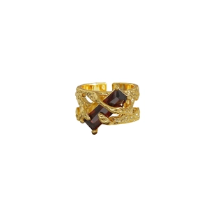 Anillo vintage dorado con textura de lava irregular y piedra preciosa roja central