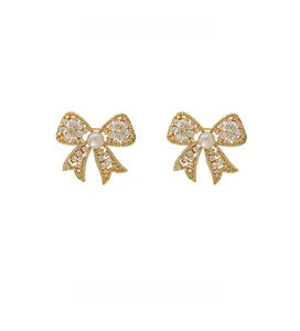 Detail shot of bow-shaped brooch featuring full cubic zirconia and freshwater pearl center