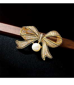 Close-up of vintage bow brooch with micro-paved crystals and a white pearl drop