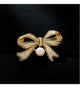 Detailed view of vintage bow brooch with pavé cubic zirconia and a round white pearl