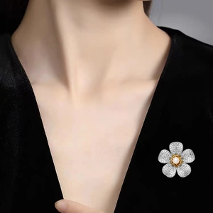 Broche fleur en zircon et perle élégante épinglée sur une robe en velours noir