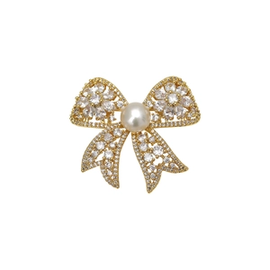 Elegant bow-shaped gold brooch with pavé zircons and a central white freshwater pearl