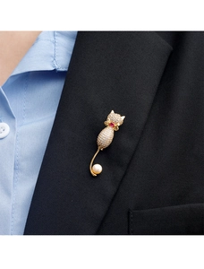 Détail d'une broche chat étincelante avec pierre rouge et perle sur un revers noir
