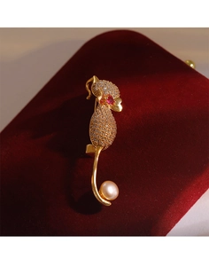 Vue détaillée de la broche chat sertie de zircons, œil rubis et perle sur velours