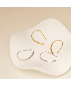 Detalle de pendientes geométricos de gota de agua minimalistas en oro y plata pulidos