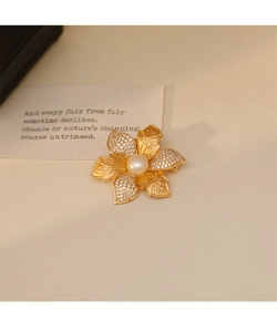Détail de la broche fleur dorée ornée de perles et de zircons étincelants