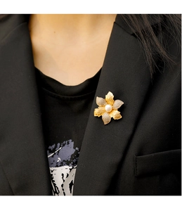 Gros plan d'une broche fleur vintage avec perles et zircons sur blazer noir