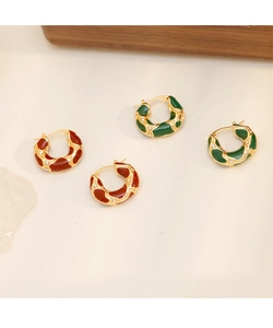 Détail de boucles d'oreilles émail vintage avec texture dorée et strass incrustés