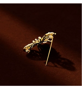 Macro shot of a golden butterfly brooch with inlaid sparkling zircons and fine plating