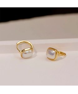 Close-up of golden pearl hoop earrings with square mother of pearl inlay and secure clasp