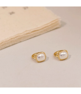 Detail of square white pearl hoop earrings with minimalist vintage gold plating