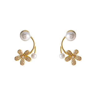 Eleganti orecchini a fiore dorati con perle e zirconi brillanti su sfondo bianco