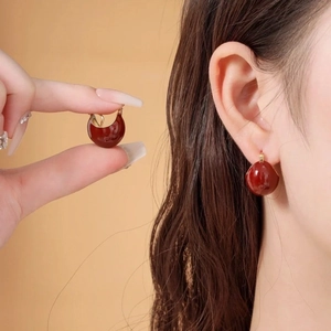 Élégantes boucles d'oreilles dôme en émail rouge foncé avec anneaux dorés sur mannequin