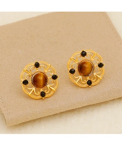 Detailed view of vintage gold hollow lace earrings with tiger eye stone on suede pouch