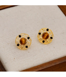 Detailed shot of vintage gold filigree earrings with tiger eye stone and black beads