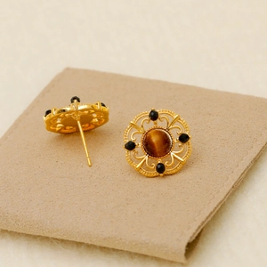 Vintage gold hollow filigree earrings featuring brown tiger eye stones and black beads
