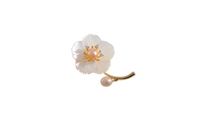 Détail d'une broche fleur avec pétales en nacre blanche et un centre en perle rose