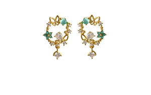 Close-up of golden flower wreath earrings with green stones and butterfly details