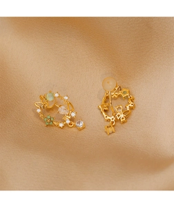 Detailed close-up of vintage gold butterfly earrings with floral patterns and zircons