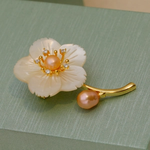 Élégante broche fleur en nacre avec perles sur fond de soie vert clair