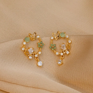 Elegant gold butterfly wreath earrings with green gemstones and zircon on silk fabric