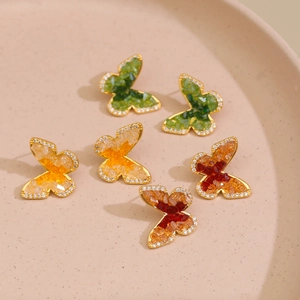 Boucles d'oreilles papillon en cristal doré avec incrustations de pierres dégradées