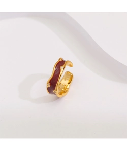 Détail d'une bague en émail bordeaux avec bords dorés et zircons scintillants