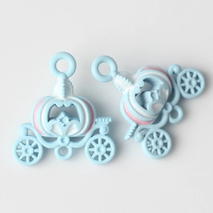 Macro view of blue enamel pumpkin carriage charms with pink and white detailing