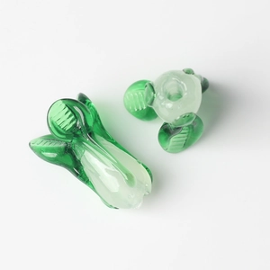 Detailed view of handcrafted lampwork glass beads in a green and white cabbage shape