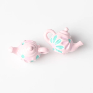 Detailed view of pink resin teapot charms with floral patterns for DIY jewelry making