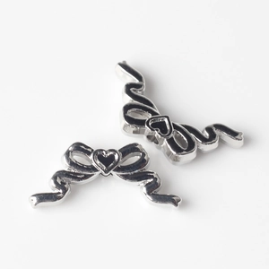 Détail macro de perles nœuds en argent avec cœur en émail noir pour bijoux DIY