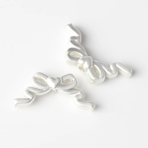 Gros plan de perles nœuds en alliage argent mat avec détail cœur pour bijoux DIY
