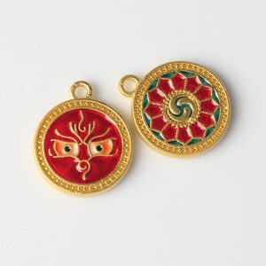 Detail of alloy enamel evil eye pendants with intricate ethnic patterns in gold and red
