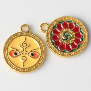 Detail of colorful alloy evil eye charms with red green geometric patterns and gold plating