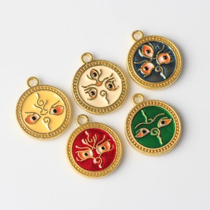 Macro view of five colorful enamel evil eye charms with gold-edged patterns for jewelry making