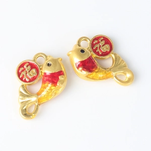 Macro detail of gold-plated fish charms with red Fu character for DIY jewelry making