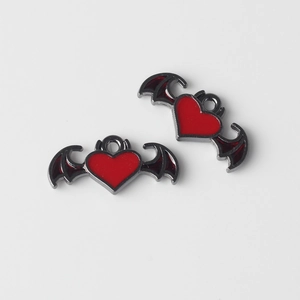 Vista macro de dijes de corazón de diablo rojo con alas para crear joyas personalizadas